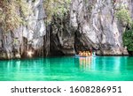 Small photo of Cave entrance of Puerto Princesa subterranean underground river with longtail boat - Wanderlust travel concept at Palawan exclusive Philippine destination - Vivid filter with bulb torch light sunflare
