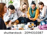 Small photo of Multicultural friends playing with mobile phone at coffee bar - People having fun together at cafeteria on brunch time - Life style concept with happy men and women at cafe venue - Bright warm filter