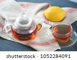 Small photo of black Bayh tea with lemon in glass teapot and glass tea mug