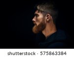 Close-up image of serious brutal bearded man on dark background Confident and dramatic concept