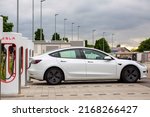 Small photo of Ulm, Germany - May 27, 2022: White Tesla Model S plugged into Tesla super chargers in highway service area at Ulm, Germany.