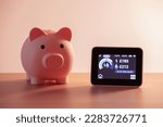 Smart meter, energy meter. Checking domestic electricity and gas use. Smart meter reading over budget. Piggy bank, savings.