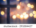 Wooden Christian Cross out of focus with a soft bokeh lights background