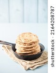 Small photo of Homemade Indian Traditional Flatbread called Chapati on a white wooden background. Baked indian flatbread. Indian