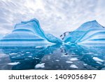 Iceberg in Antarctica floating in the sea, frozen landscape with massive pieces of ice reflecting on water surface, Antarctic Peninsula
