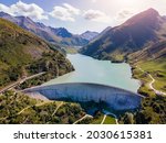 Water dam and reservoir lake in Swiss Alps generating hydroelectricity. Aerial view of arch dam between mountains. Hydropower green energy for sustainable development against global warming. Zero CO2