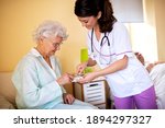 Small photo of Brunette lady doctor and her nursing home elder woman patient having polite conversation, skilled nursing facility concept