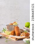 Small photo of Meat croquets with garlic mayonnaise, lime slices to season and rosemary leaves on wooden table in a kitchen counter top.