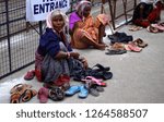 Small photo of HYDERABAD,INDIA-DECEMBER 19:Indian senior women keep guard of foot wear of devotees,who leave them, outside the temple,for money on December 19,2018 in Hyderabad