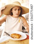 Small photo of A young woman eating an unsavoury dinner in an Italian restaurant