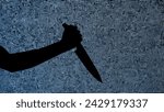Small photo of Silhouette against digital television screen. Thriller scene woman hand holding knife and stabbing it against digital screen with noise.