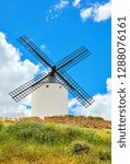Small photo of Wind mill at knolls at Consuegra, Toledo region, Castilla La Mancha, Spain. Route of Don Quixote with windmills. Summer landscape with blue sky and clouds.