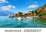Small photo of Varenna, Italy. Picturesque town at lake Como. Colourful motley Mediterranean houses stone beach coastline among green trees. Popular luxury health resort and touristic location. Summer day landscape