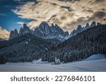 St. Magdalena or Santa Maddalena with its characteristic church in front of the Geisler or Odle dolomites mountain peaks in the Val di Funes Villnosstal in Italy in winter. January 2023. Long exposure