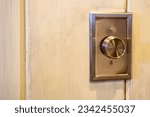 Small photo of Closeup of metal rotary dimmer knob for overhead lights on interior wall