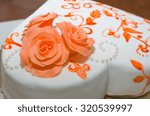 Heart Shaped White Wedding Cake with Orange Roses and Pearl Decoration Closeup