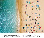 Aerial View From Flying Drone Of People Crowd Relaxing On Beach In Portugal