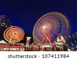 Sydney city luna park illuminated at sunset with blurred moving attractions wheels