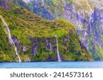 Small photo of Steep rocky mountain peaks around Milford Sound fiord on South Island of New Zealand with Stirling falls.
