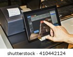 POS terminal in coffee cafe waiter's hand when serving customers and touching screen of a tablet with software interface to take order and print receipt.