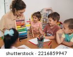 Small photo of teacher teaching children in daycare