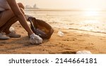 Small photo of Volunteer woman picking plastic bottle into trash plastic bag black for cleaning the beach, female clean up garbage at sunset, Ecology concept and World Environment Day, Save earth concept