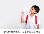 Small photo of Asian toddler smiling happy wear student thai uniform red pants keeps pointing finger at copy space in studio shot isolated on white background, Portrait little children boy preschool, Back to school
