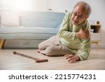 Small photo of Sick senior old man falling down lying on the ground because stumbled at home alone with wooden walking stick in living room, elderly man grandfather having accident while walk with cane walker
