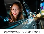 Asian businesswoman commuting from office in Taxi backseat with mobile phone on road in city at night after late work, Beautiful woman using smartphone sitting back seat her car in urban