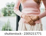Small photo of Sad Woman Stomach Ache from menstruation. young female unhappy unwell sick ill hand holding on stomach suffers pain at home, Abdomen bloating and Chronic gastritis concept