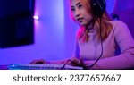 Small photo of Happy Gamer endeavor plays online video games tournament with computer neon lights, young woman wearing gaming headphones intend to do playing live stream games online at home