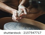 Woman hands working on pottery wheel making a clay pot, raw clay shaping, traditional craft