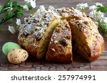  Easter decoration - sweet braided homemade with easter eggs and florets with leaves decorated on wooden desk - table - easter time