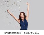 Beautiful happy woman at celebration party with confetti falling everywhere on her. Birthday or New Year eve celebrating concept