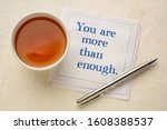 Small photo of You are more than enough - inspirational handwriting on a napkin with a cup of tea, pep talk, self esteem and personal development concept
