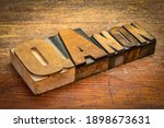 Small photo of QAnon word abstract in vintage letterpress wood type againdt rudtic wooden background, disproven and discredited far-right conspiracy theory