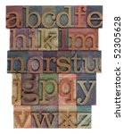 Small photo of English alphabet (lower case) in vintage wooden letterpress type, stained by inks of different colors, flipped horizontally, isolated on white