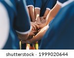 Small photo of Sports team stacking hands together in a group. Happy children teammates motivated in a team. Team building activities and boosting sports players' morale. Schoolboys building team spirit before game