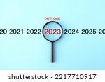 Magnifying glass and 2023 with OUTLOOK word