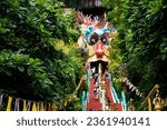 Antique red stairs of Chinese Dragon Tunnel to Ku Ha Mangkorn Sawan or Bua Kli Cave of Wat Ban Tham temple for thai people travel visit respect praying blessing holy mystical in Kanchanaburi, Thailand