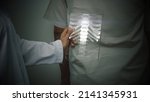 Small photo of Futuristic concept of a doctor using an advance transparent x-ray pad scanning a patient's backbone looking for a sign of spinal disc herniation