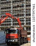 Small photo of Milan,Italy - May 24 2018: Modern excavator performs excavation work and dumber truck, industrial machinery on building site.
