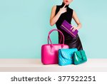 Woman choosing the bag from many colorful bags.Isolated on light blue background. Shopping addiction. 