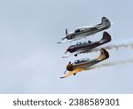 Small photo of LITTLE GRANSDEN, CAMBRIDGESHIRE, ENGLAND - AUGUST 27, 2023: Vintage Yakovlev Yak 18T ,Yak 50 and 52 in close formation flight against blue sky.
