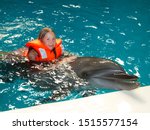 Portrait of young girl swimming with smart dolphin  