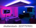Moving to a new house. House interior. Ideas for basement living room. Entertainment room with TV and color led strips.