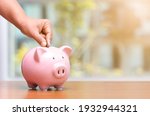 Small photo of Concept hand putting money coin into piggy bank saving money for future plan and retirement fund, Business or finance saving show putting coin saving and investment money retro vintage color tone.