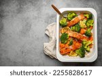 Small photo of Top view of healthy baked fish salmon steaks, broccoli, cauliflower, carrot in casserole dish on gray stone background. Cooking a delicious low carb dinner, healthy nutrition concept. Space for text