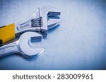 Small photo of Metallic background with adjustable spanner and hook wrench repairing concept
