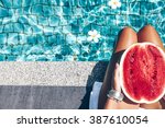 Girl holding watermelon in the blue pool, slim legs, instagram style. Tropical fruit diet. Summer holiday idyllic.